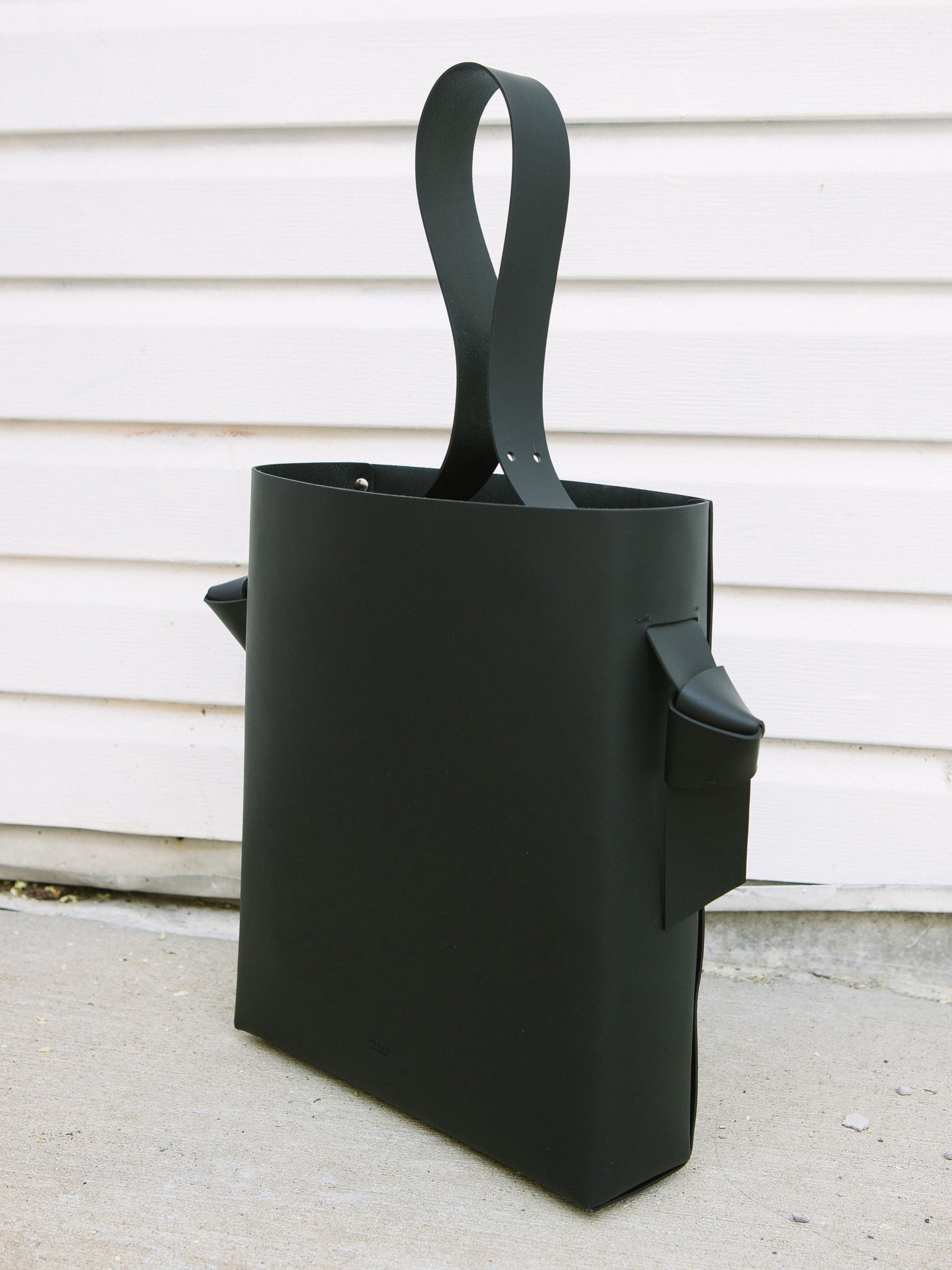 Chic black tote and bucket bag crafted from Italian vegetable tanned leather for a minimal yet sophisticated look.