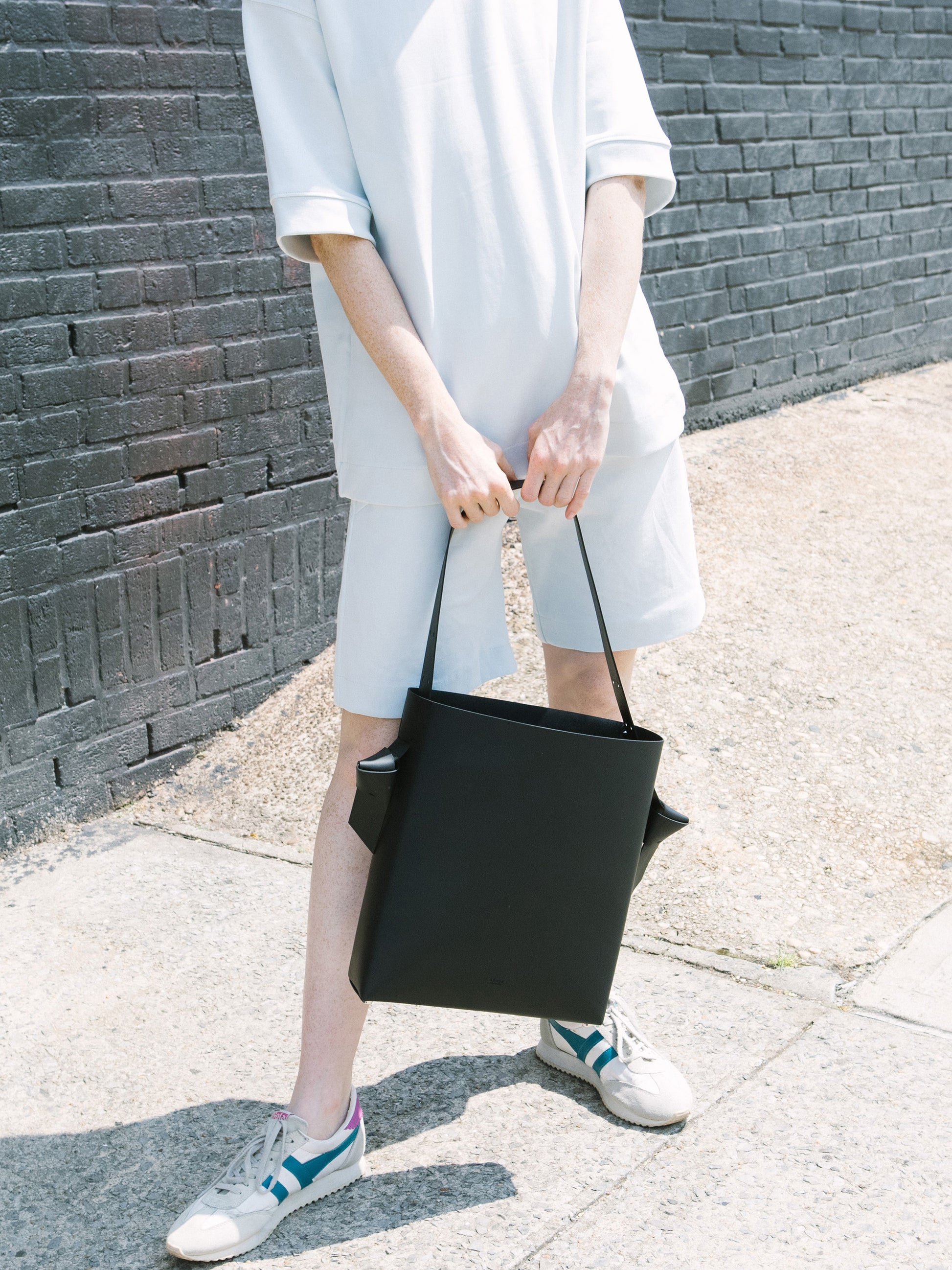 Chic black tote and bucket bag crafted from Italian vegetable tanned leather for a minimal yet sophisticated look.