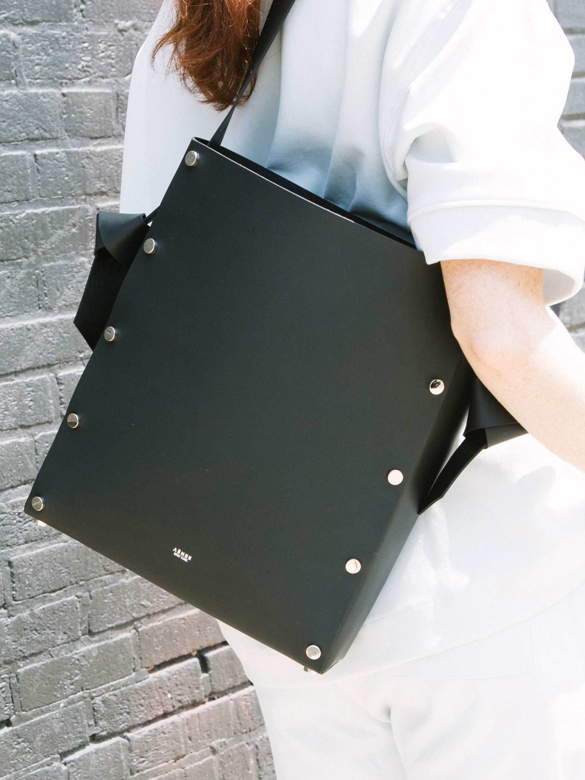 Chic black tote and bucket bag crafted from Italian vegetable tanned leather for a minimal yet sophisticated look.