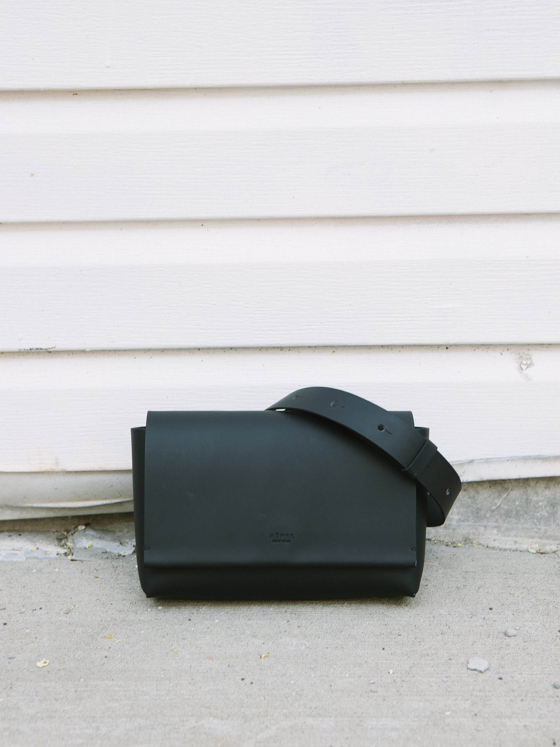 Chic black designer belt bag and fanny pack crafted from Italian vegetable tanned leather for a minimalist yet sophisticated look.
