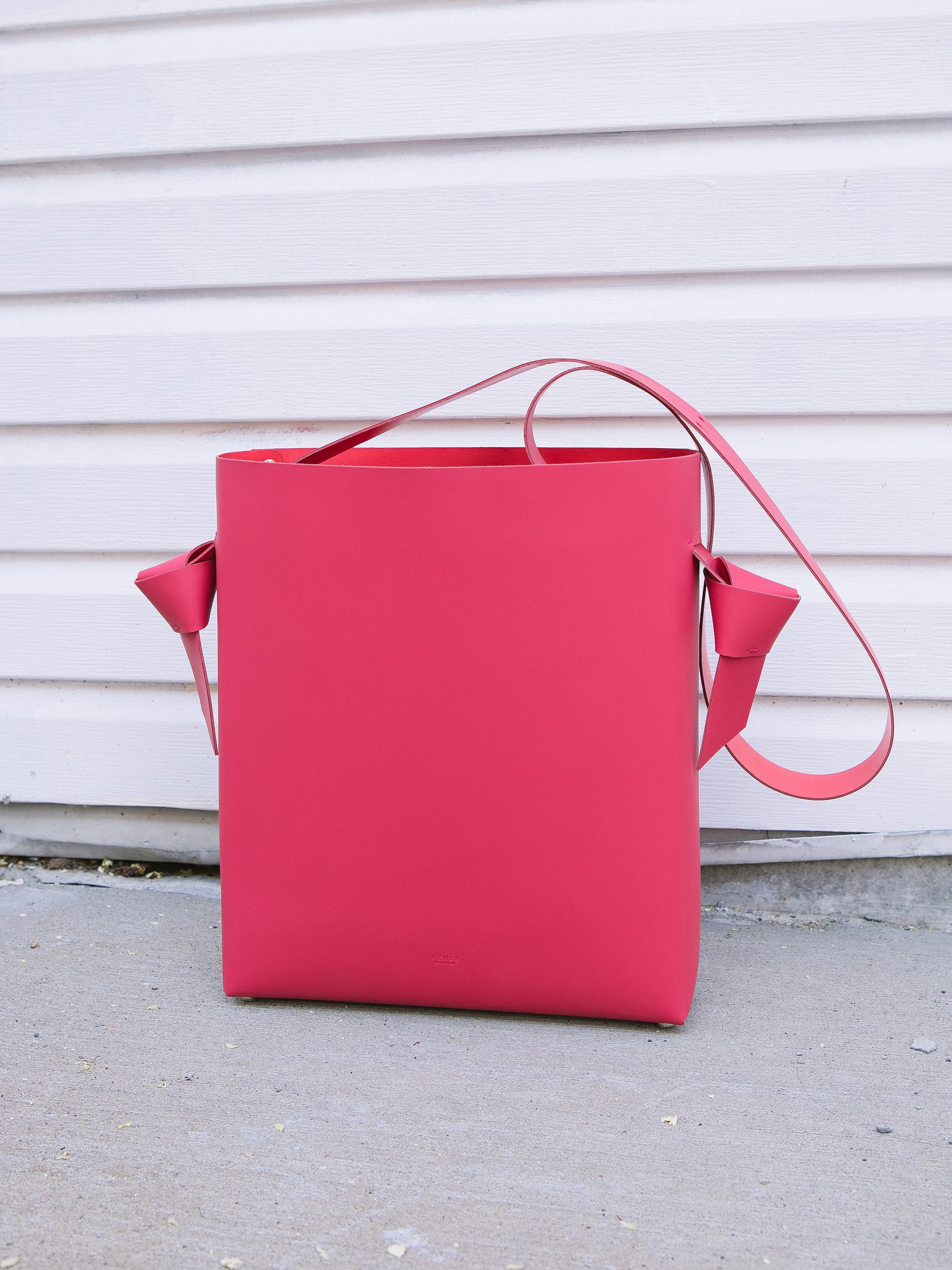 Chic red tote and bucket bag crafted from Italian vegetable tanned leather for a minimal yet sophisticated look.