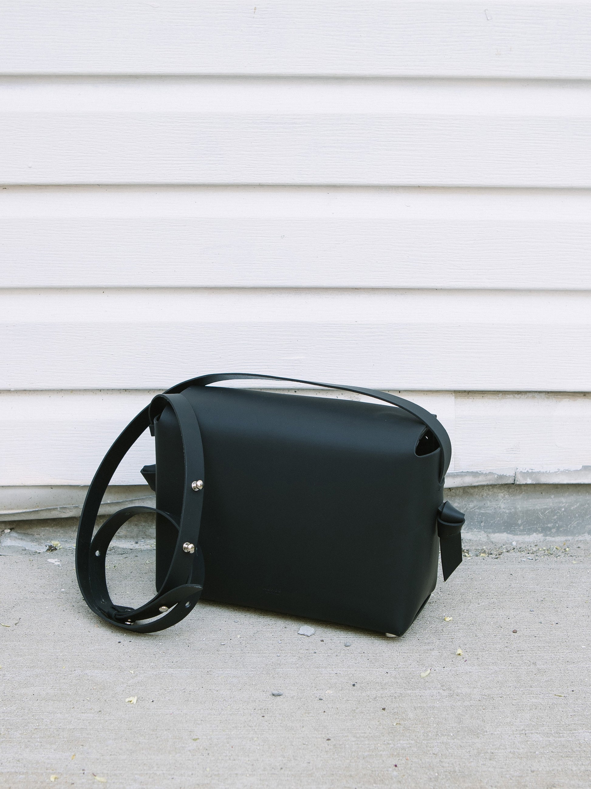 Chic black crossbody bag and shoulder bag with adjustable strap crafted from Italian vegetable tanned leather for a minimal yet sophisticated look.